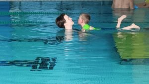 Child enjoying personalized swimming lesson with instructor in a pool, emphasizing Aqua Life Swim Academy's focus on fun and safety.